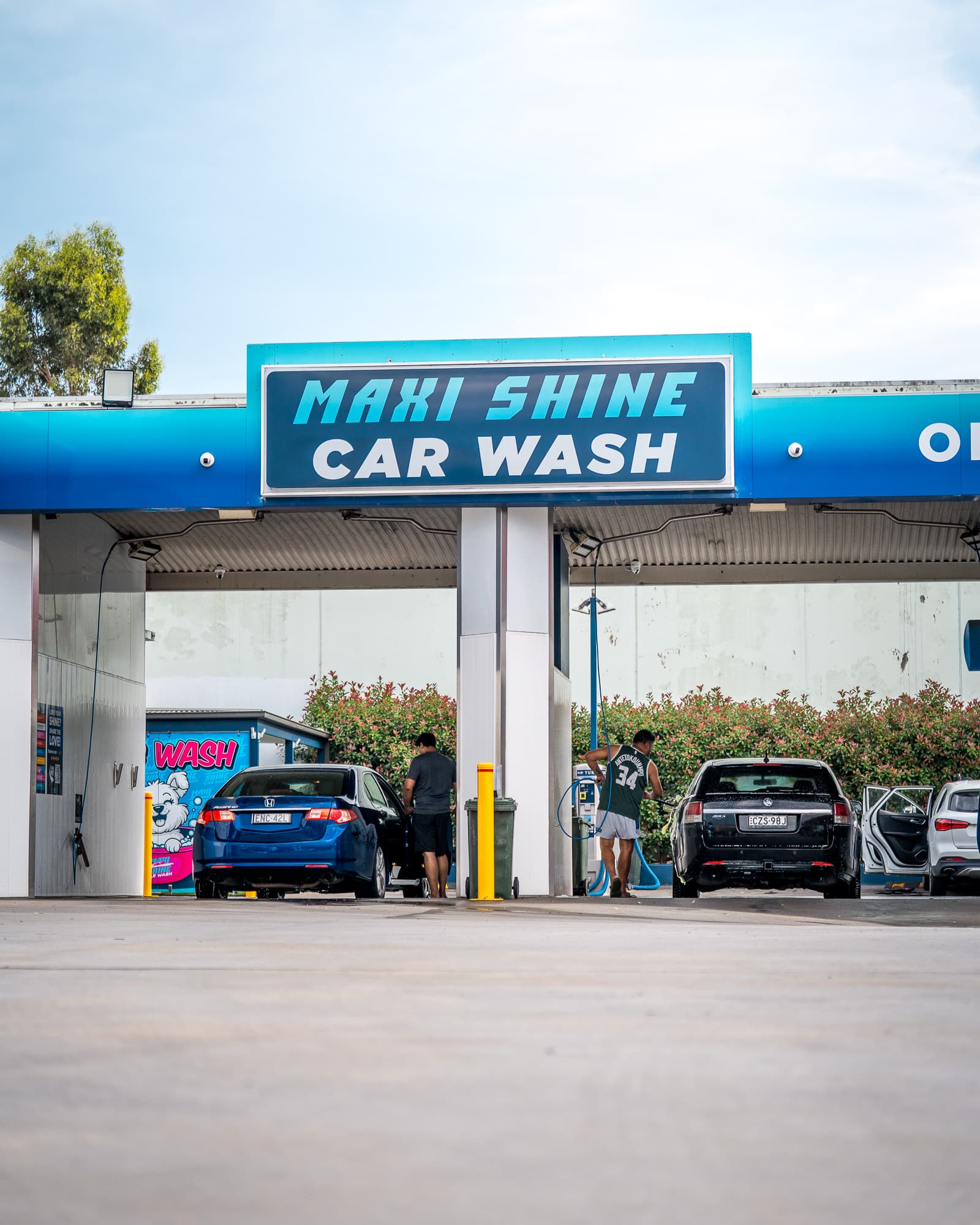 Driver washing their car at a Maxishine self-service bay