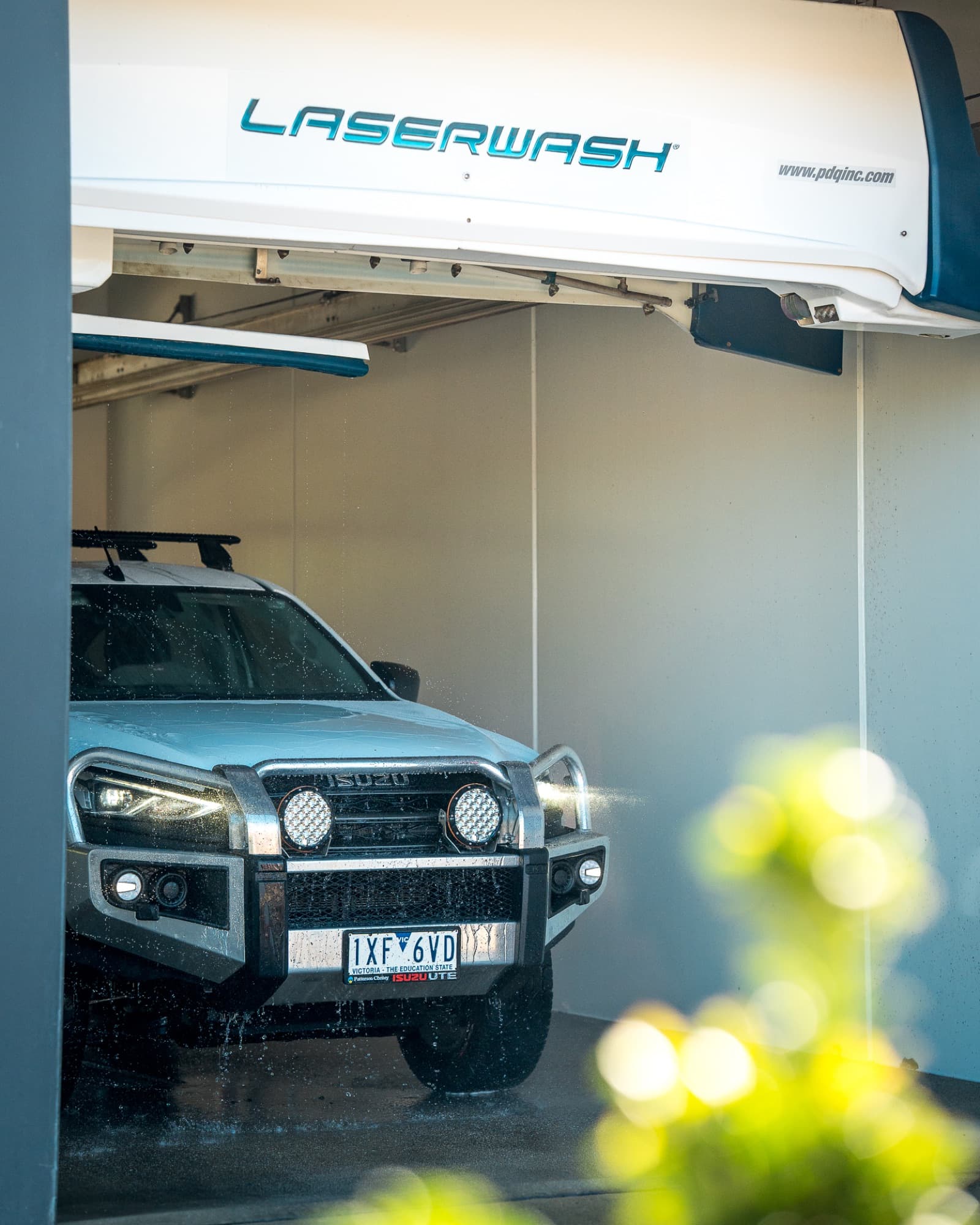 A fleet Isuzu ute mid-wash in a Maxishine Laserwash 360 touchless bay