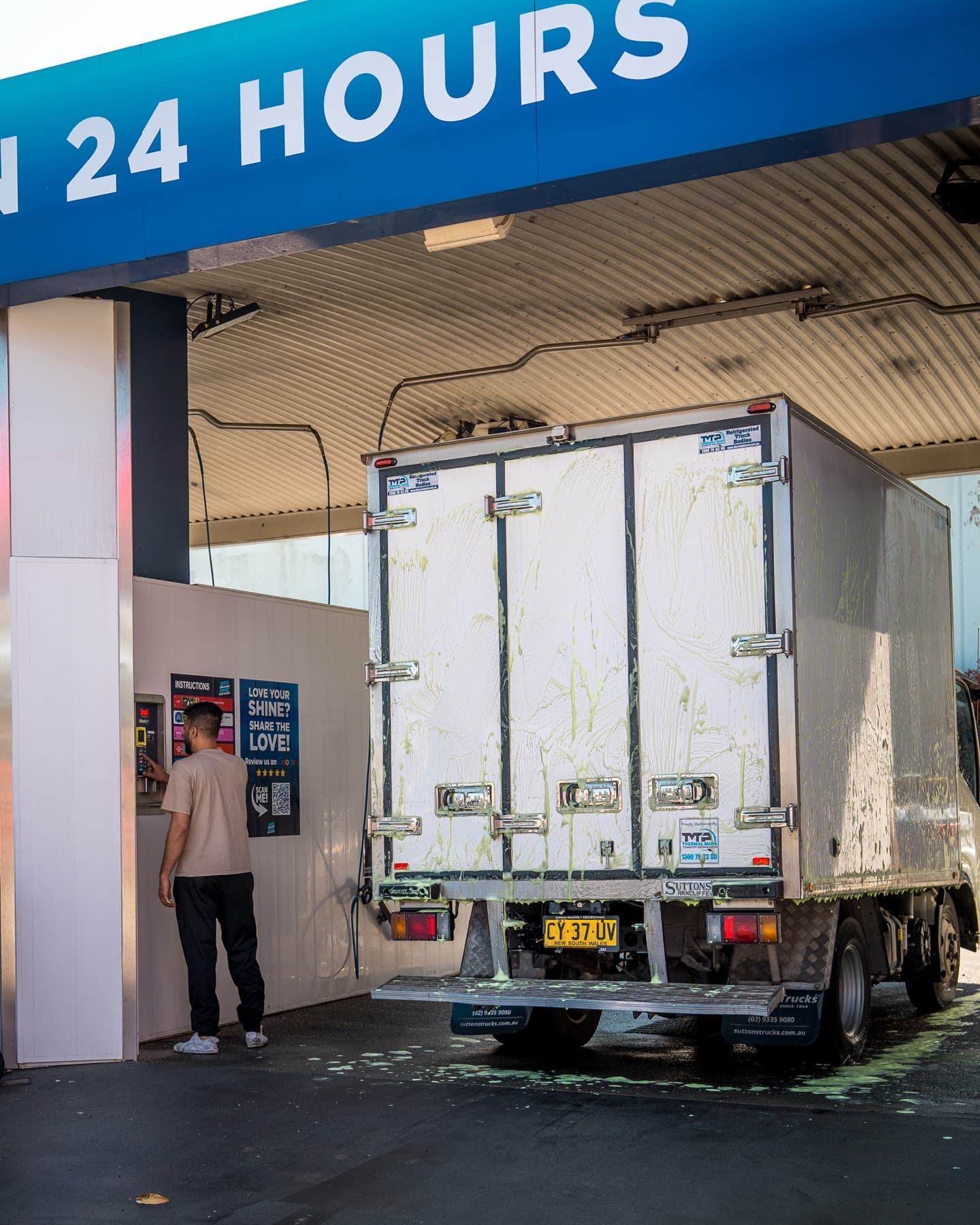 A refrigerated Isuzu truck being washed in a Maxishine bay
